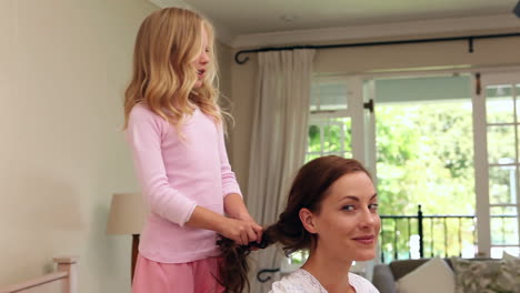 Little-girl-plaiting-her-mothers-hair-in-the-morning