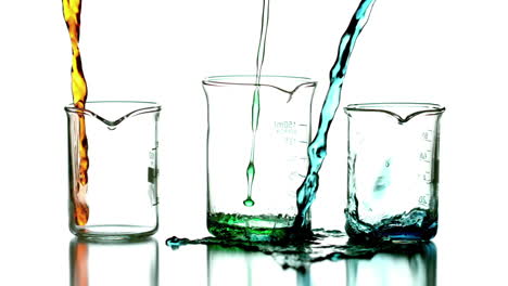Liquid-pouring-into-beakers-on-white-background