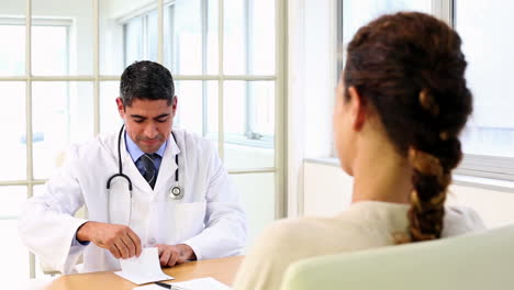 Doctor-speaking-with-his-sick-patient-at-desk