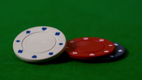 Casino-chips-falling-on-green-table