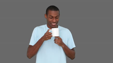 Casual-young-man-enjoying-cup-of-coffee