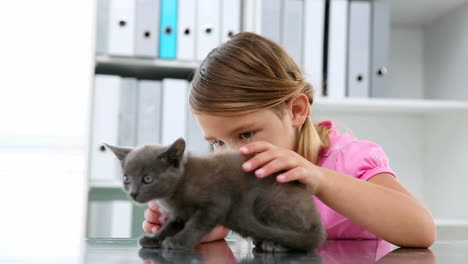 Little-girl-stroking-a-grey-kitten