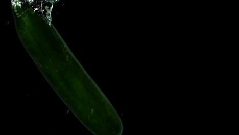 Courgette-falling-in-water-on-black-background