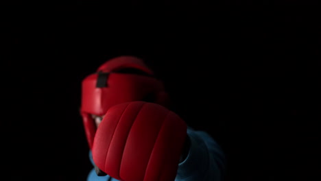 Sporty-young-man-boxing-on-black-background