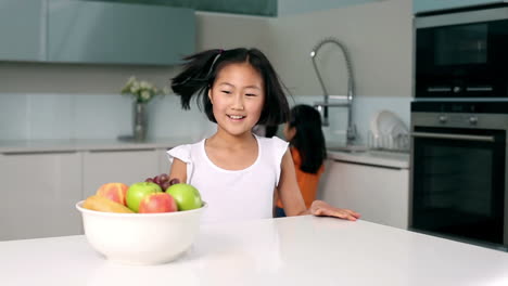 Little-girl-taking-apple-out-of-bowl