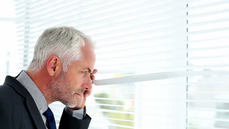 Businessman-spying-through-blinds