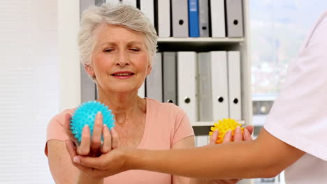 Nurse-showing-elderly-patient-how-to-use-massage-balls