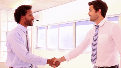 Businessmen-shaking-hands-and-smiling