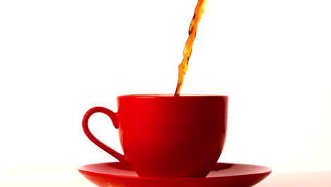 Hot-tea-pouring-into-red-cup