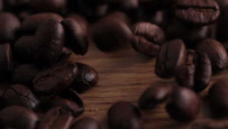 Coffee-beans-pouring-onto-wooden-surface