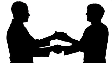 Silhouette-of-businessmen-shaking-hands-while-passing-a-bribe-