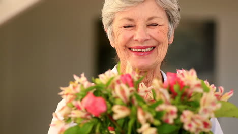 Senior-woman-smelling-bouquet-of-flowers