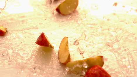 Apple-pieces-falling-and-bouncing-on-white-wet-surface