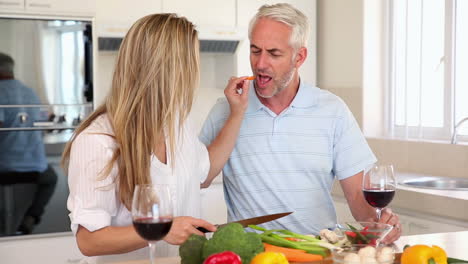 Pareja-Feliz-Bebiendo-Vino-Tinto-Juntos-Mientras-Preparan-La-Cena