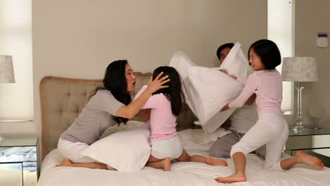 Silly-family-having-a-pillow-fight-on-bed