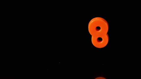 Orange-number-eight-falling-on-black-background