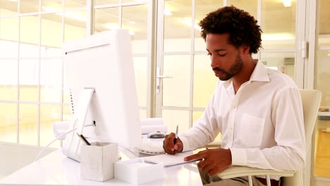 Businessman-taking-notes-at-his-desk