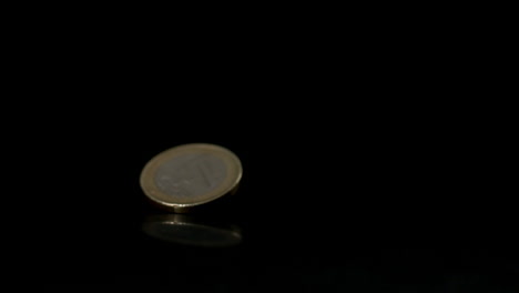 Euro-coin-falling-on-black-surface