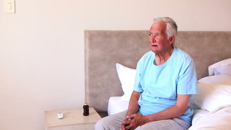 Elderly-man-sitting-on-his-bed