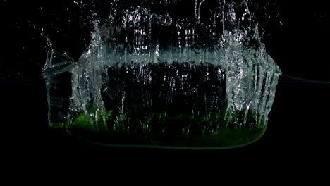 Courgette-falling-in-water-on-black-background