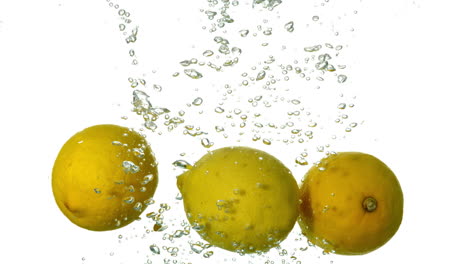 Lemons-plunging-into-water-on-white-background