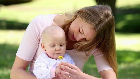 Madre-Feliz-Sosteniendo-A-Su-Bebé-En-El-Parque