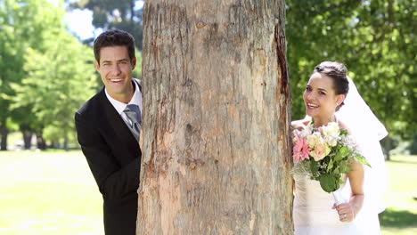 Felices-Recién-Casados-Posando-En-El-Parque-Junto-A-Un-árbol