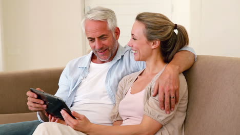 Glückliches-Paar,-Das-Zusammen-Auf-Der-Couch-Tablet-Benutzt