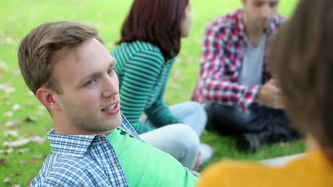 Glückliche-Studenten-Die-Zusammen-Auf-Dem-Rasen-Plaudern