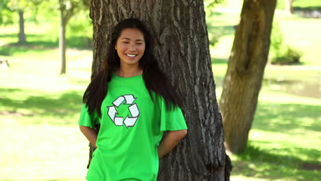 Happy-environmental-activist-leaning-against-a-tree