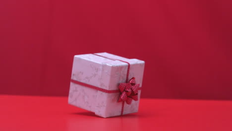 Christmas-gift-dropping-and-bouncing-on-red-background