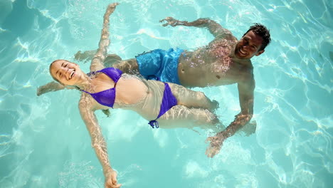 Happy-couple-swimming-in-a-pool