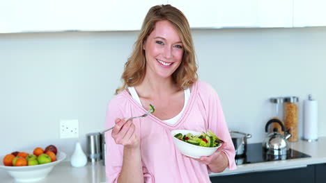 Pretty-woman-standing-eating-a-bowl-of-salad