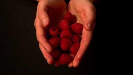 Frau-Schüttet-Himbeeren-Aus-Ihren-Händen