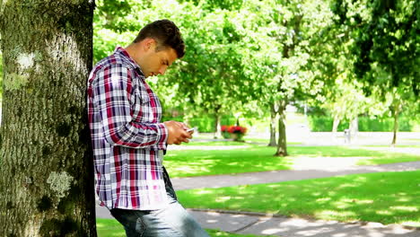 Junger-Student-Benutzt-Sein-Smartphone-Draußen