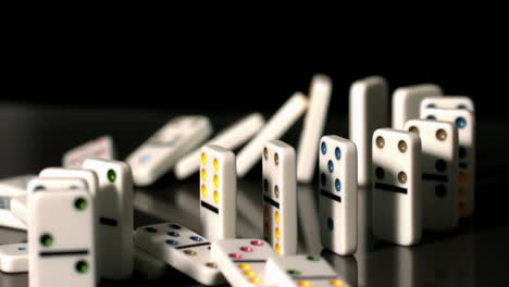 Finger-pushing-over-colourful-dominoes