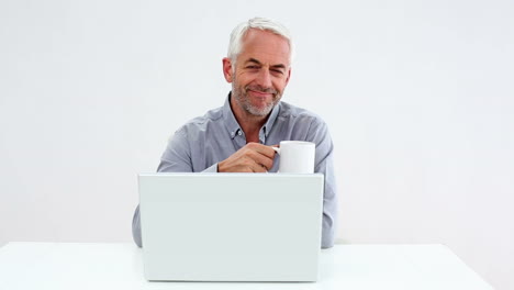 Casual-businessman-working-on-laptop-and-drinking-coffee