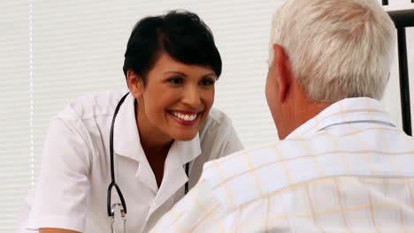 Enfermera-Hablando-Con-Un-Paciente-Anciano-En-Silla-De-Ruedas
