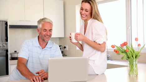 Happy-couple-having-coffee-together-and-using-laptop