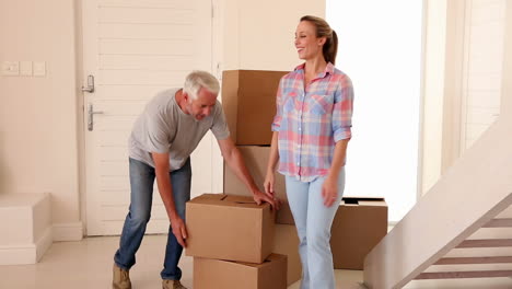 Couple-carrying-boxes-into-empty-room