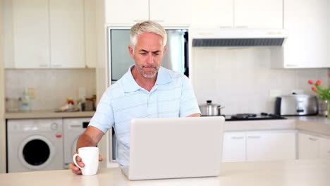 Casual-man-using-laptop-at-the-counter