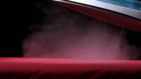 Iron-releasing-steam-above-a-red-cloth