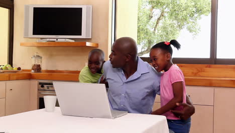 Father-using-the-laptop-with-his-children