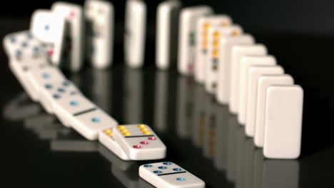 Finger-pushing-over-colourful-dominoes