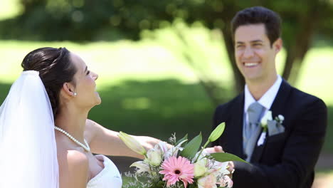 Happy-newlyweds-standing-in-the-park-holding-hands