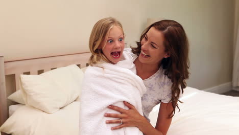Mother-sitting-with-her-little-girl-wrapped-up-in-a-towel