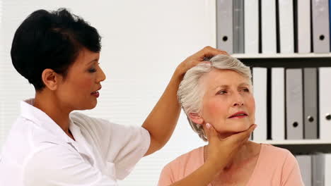 Enfermera-Mostrando-A-Una-Paciente-Anciana-Cómo-Ejercitar-Su-Cuello-Lesionado