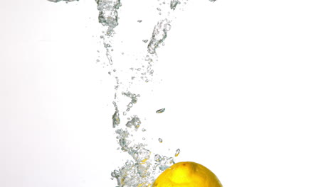 Zitrone-Eintauchen-In-Wasser-Auf-Weißem-Hintergrund