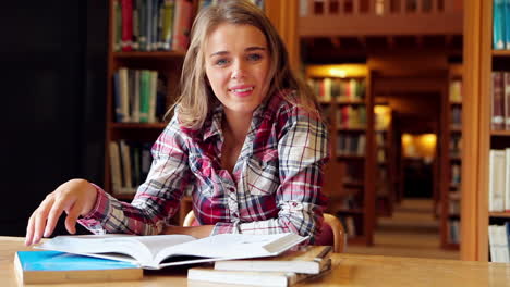 Happy-student-studying-at-desk-in-the-library