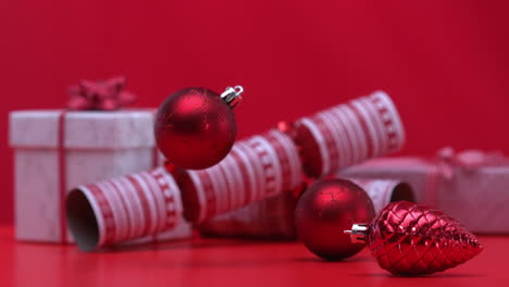 Christmas-decorations-spinning-and-falling-beside-crackers-and-presents